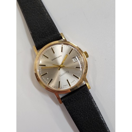 376 - A Garrard vintage gold plated quartz date/just on a leather strap.