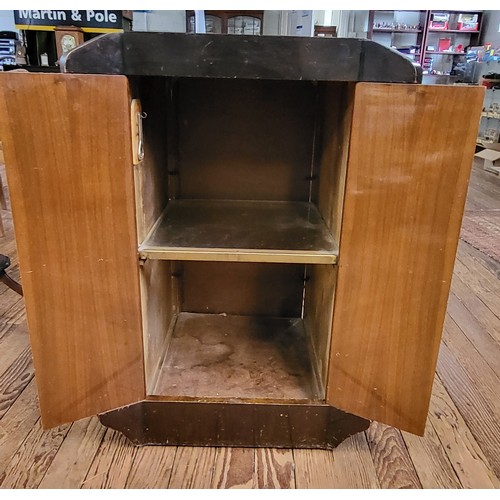 22 - A 1930's drinks cabinet with two doors and glass shelf, and including a bottle opener. Veneer chippe... 