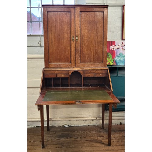 5 - An oak bookcase on bureau. Two doors cupboard with three shelves over a fold down writing desk with ... 