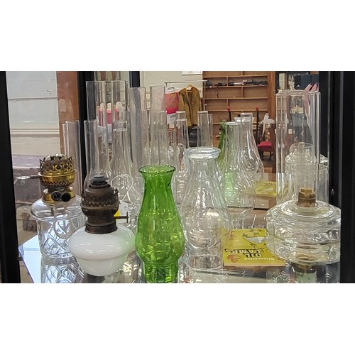 204 - Fifteen glass oil lamp chimneys and three oil lamp bases. (18)