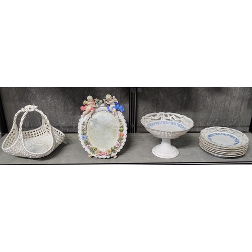 205 - A German porcelain oval mirror with two cherubs and encrusted roses 28cm, six pierced border plates ... 