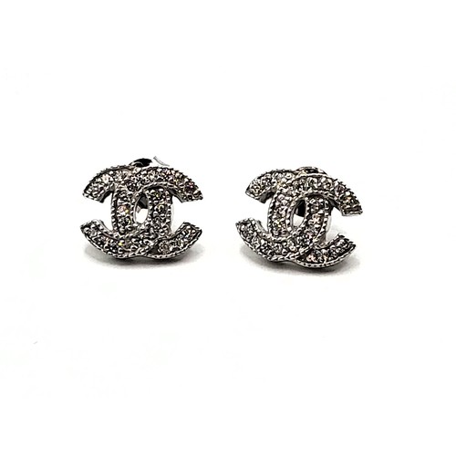 270 - A pair of silver (925) cubic zirconia designer style stud earrings. 4.0gms. 1cm.