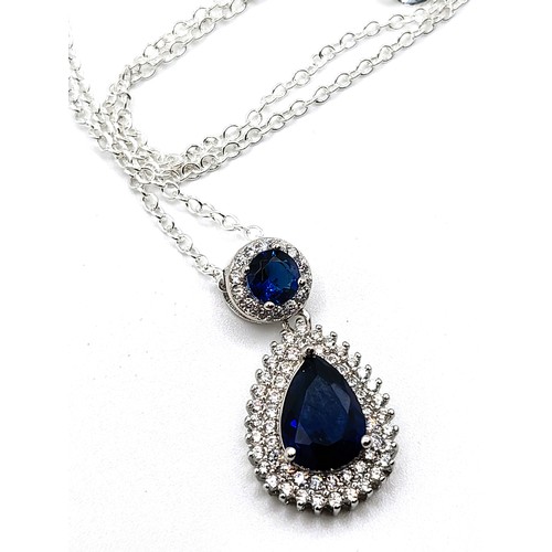 272 - A silver faux sapphire and cubic zirconia articulated pear shaped and round pendant on a silver colo... 