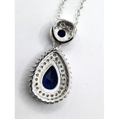 272 - A silver faux sapphire and cubic zirconia articulated pear shaped and round pendant on a silver colo... 