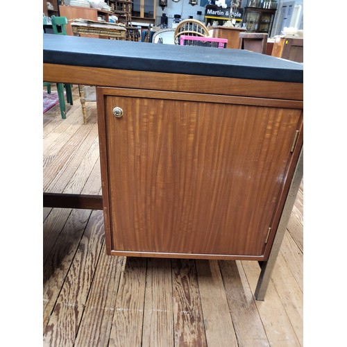 50 - A mid-century leather topped desk with drawers at the front and cupboards at the rear. 71cm x 169cm ... 