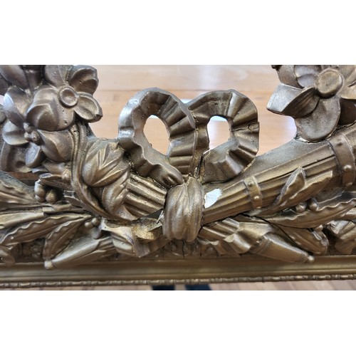 11 - Ornate gilt framed mirror 101cm x 56cm.