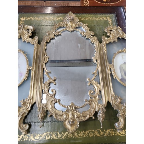 14 - Ornate brass dressing table mirror flanked by photo frames. 43cm x 62cm.