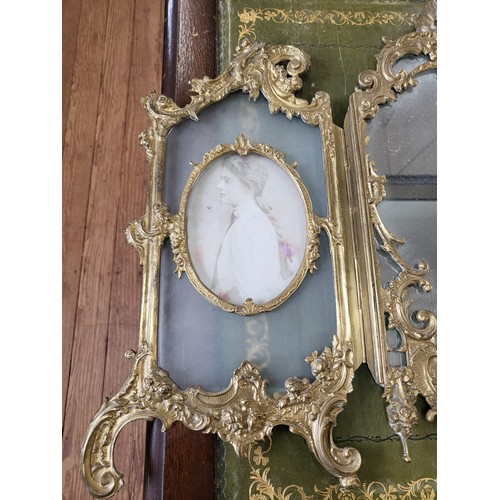 14 - Ornate brass dressing table mirror flanked by photo frames. 43cm x 62cm.