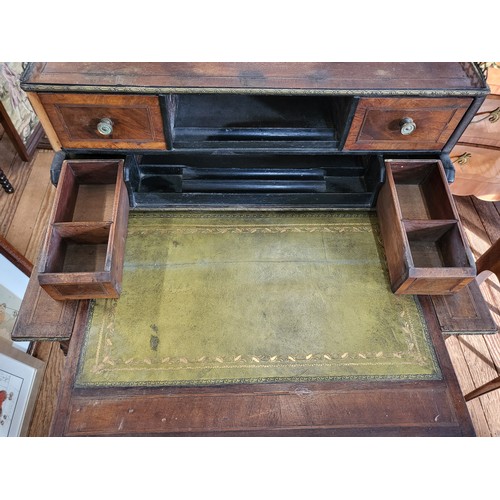 16 - A mahogany writing desk with a gallery around the top, two small drawers and a pigeon hole, two smal... 