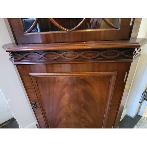 38 - A reproduction corner cabinet in a mahogany finish. 202cm x 70cm x 47cm