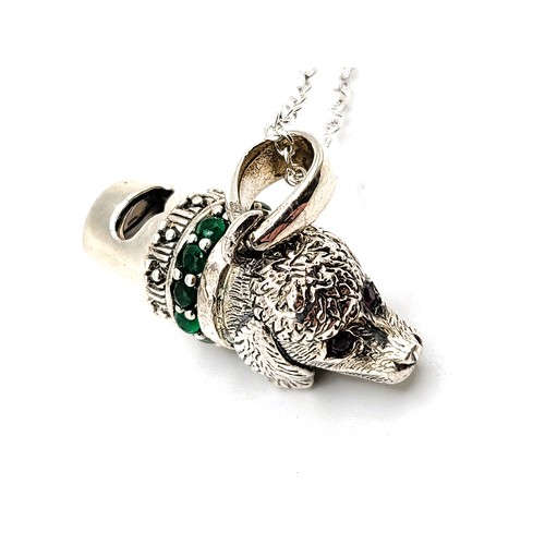 267 - A silver dog's head whistle with green glass collar and ruby eyes, on a 46cm silver chain, 10.0gms.