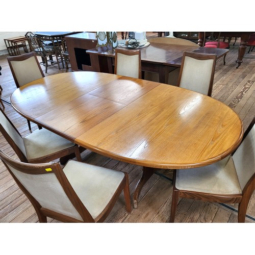 23 - A G-Plan extending oval dining table and a set of six chairs with light upholstery. 73cm x 208cm (fu... 