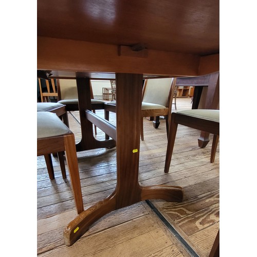 23 - A G-Plan extending oval dining table and a set of six chairs with light upholstery. 73cm x 208cm (fu... 