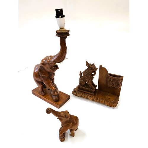 88 - Three wooden ornaments including an elephant lamp, a baby elephant, and a Burmese style lion.