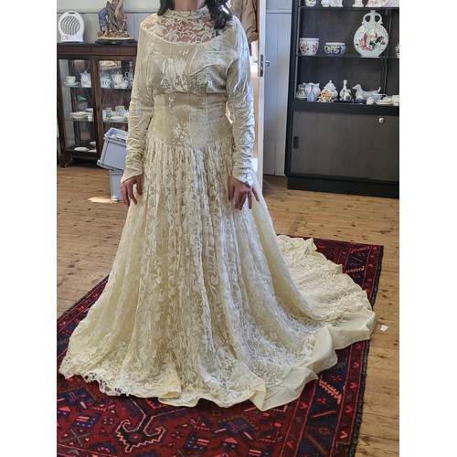 97 - A 1950's wedding dress with a crushed velvet bodice, long tapered sleeves with a V finish, ivy leaf ... 