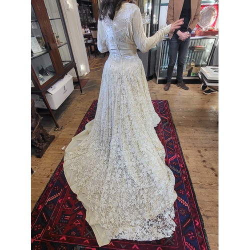 97 - A 1950's wedding dress with a crushed velvet bodice, long tapered sleeves with a V finish, ivy leaf ... 