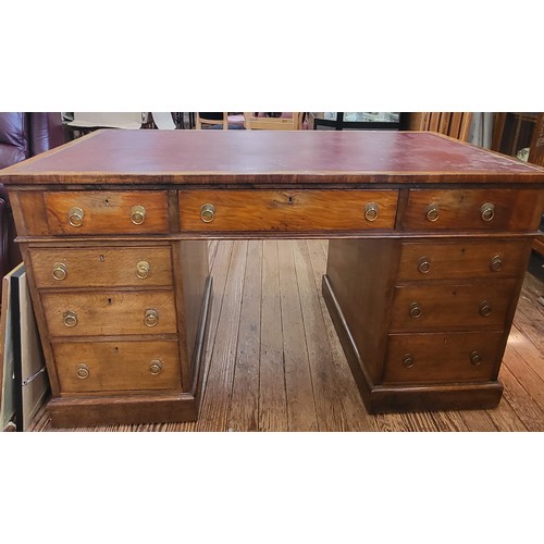 18 - A pedestal desk in three sections with a red leather top, a central drawer, flanked by four drawers ... 