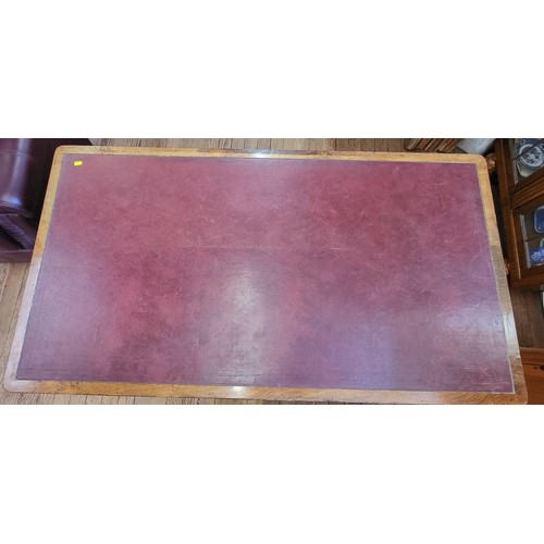 18 - A pedestal desk in three sections with a red leather top, a central drawer, flanked by four drawers ... 