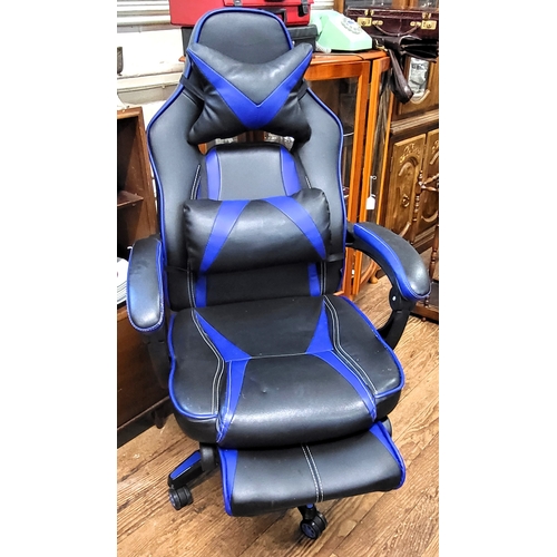 28 - A black and blue gaming chair with pull out rest for legs and adjustable lumbar and head support.