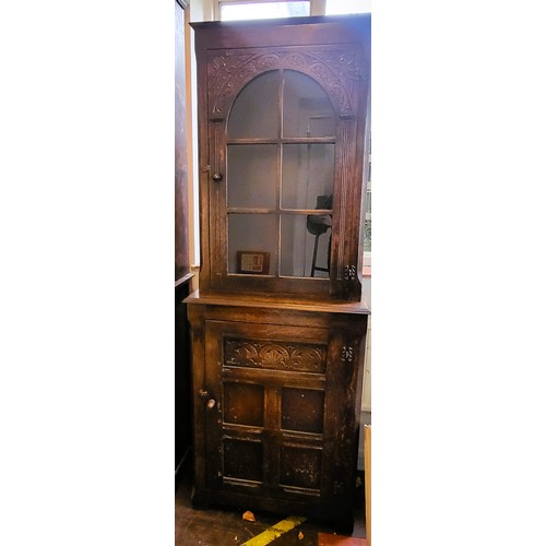 54 - A carved oak display cabinet in the Ipswitch oak style H: 185cm W: 68cm D: 32cm.