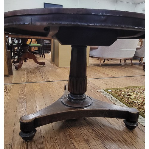 69 - A circular dining tilt table with a burr elm top (some damage) on a carved pedestal and tripod legs.... 