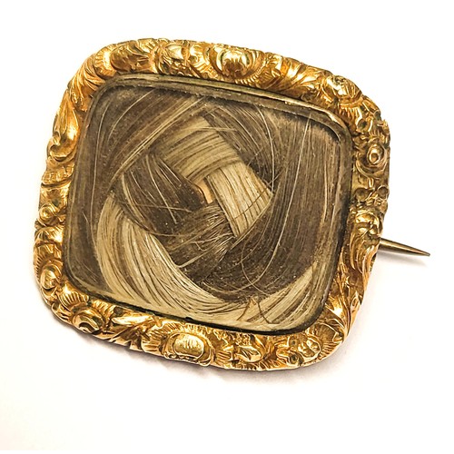 393 - A 12ct rose gold Victorian Memento Mori brooch with a braided lock of hair in an ornate surround. En... 
