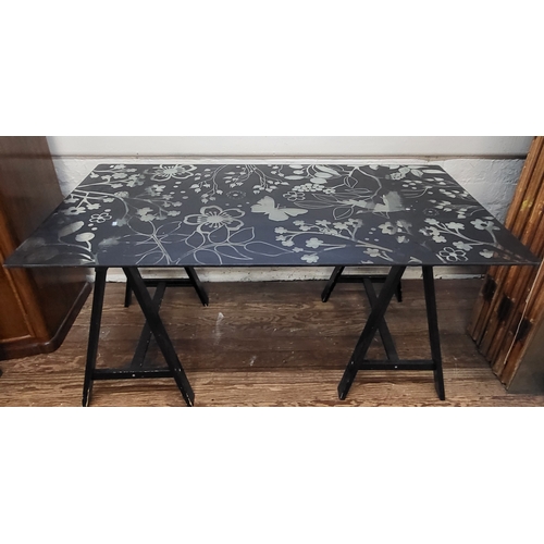 44 - An etched floral design glass black table with a pair of A-frame legs.