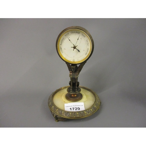 1729 - 19th Century gilt brass and onyx desk barometer, the enamel dial within a drum form case supported b... 