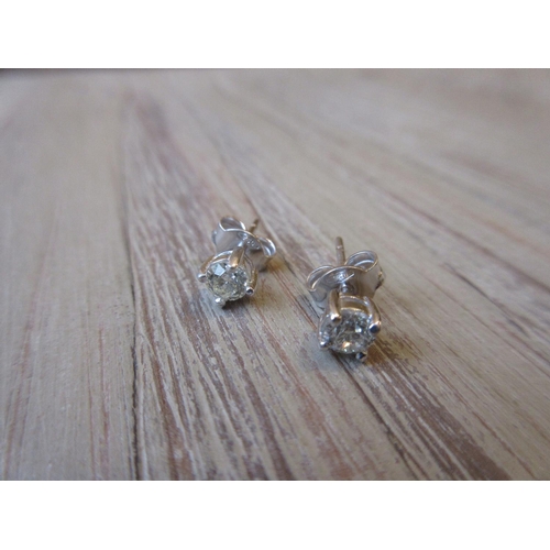 1046 - Pair of 18ct white gold diamond solitaire ear studs, approximately 0.50ct total