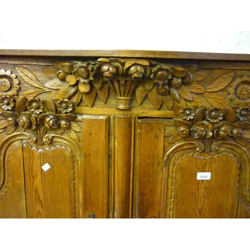 2233 - 19th Century French low pine armoire, the frieze carved with a basket of flowers above two carved pa... 