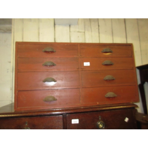 2348 - 19th Century red painted pine bank of eight drawers having cast iron cup handles, 17ins high x 33ins... 