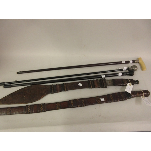 194 - Two African native spears, two swords with leather grips, walking stick etc