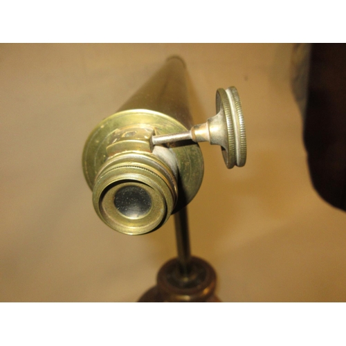 289 - Early 20th Century brass sighting scope mounted on an iron tripod stand