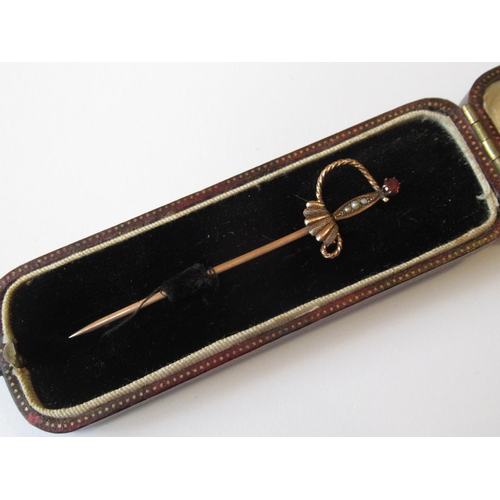 1063 - Yellow metal split pearl and garnet stick pin in the form of a sword in fitted case