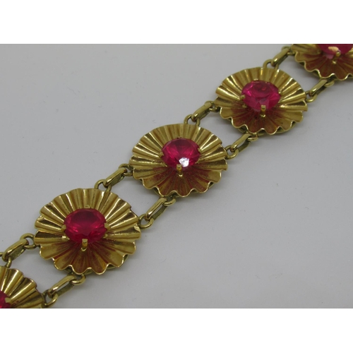 1081 - Mid 20th Century yellow metal and synthetic ruby bracelet of repeating linked flowerhead design