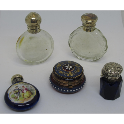 1103 - Two Circular clear glass scent bottles with silver covers, together with a porcelain scent bottle, a... 