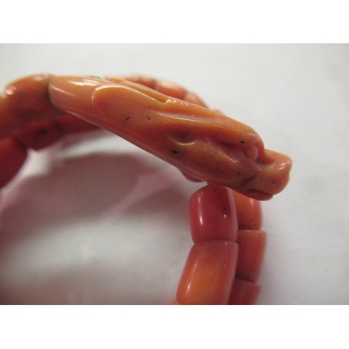 1131 - Coral expanding bangle with carved dragon's head finial, together with a quantity of other coral and... 