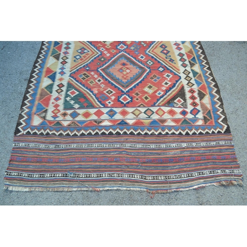 17 - Kelim rug with a twin medallion design on a red ground with borders, 9ft 8ins x 5ft 4ins approximate... 