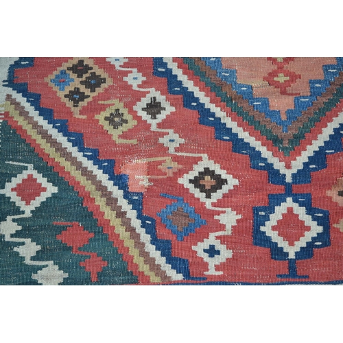 17 - Kelim rug with a twin medallion design on a red ground with borders, 9ft 8ins x 5ft 4ins approximate... 