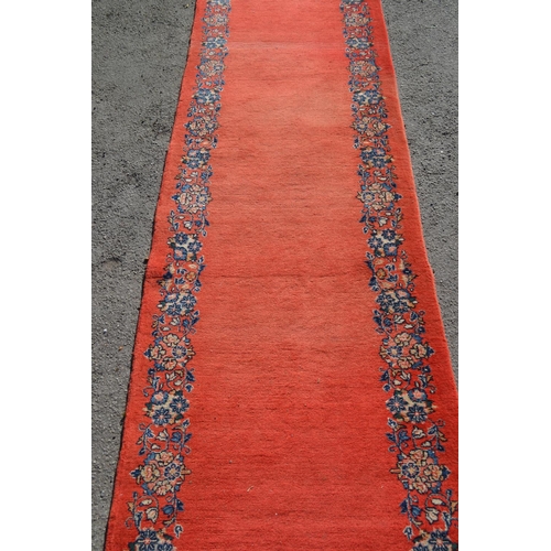 37 - Unusual mid 20th Century central Persian runner, the plain red field with a repeating floral border,... 