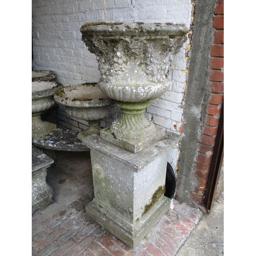 976 - Weathered cast concrete pedestal garden urn with grape vine decoration, 53ins high