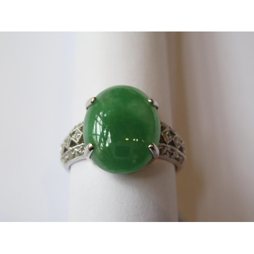 719 - 18ct White gold oval jade set ring with diamond set shoulders