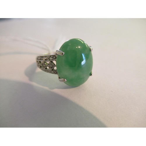 719 - 18ct White gold oval jade set ring with diamond set shoulders