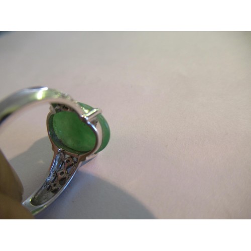 719 - 18ct White gold oval jade set ring with diamond set shoulders