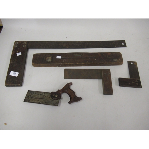 258 - A small collection of tools including three set squares, spirit level and a small wooden handled saw