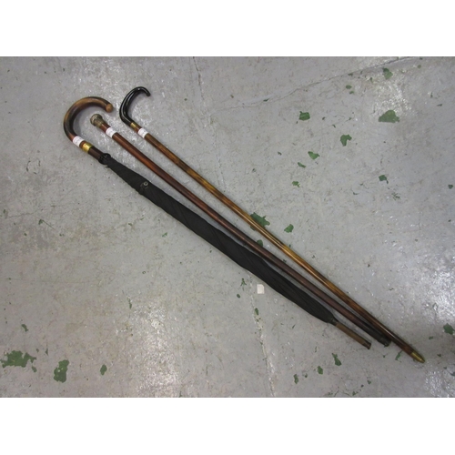 304A - Silver topped walking cane, another walking cane and an umbrella with gold plated mount