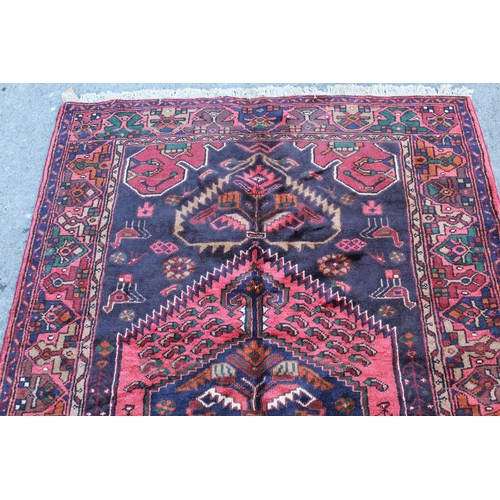 7 - Zanjan rug with a medallion and all-over stylised design on a dark ground with borders, 2.06m x 1.4m