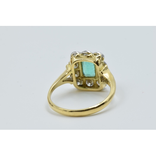 879 - 18ct Yellow gold ring set emerald surrounded by brilliant cut diamonds