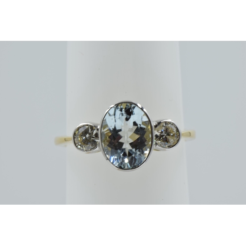 897 - 18ct Yellow gold ring set oval aquamarine flanked by two brilliant cut diamonds