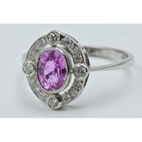 898 - Platinum ring set oval pink sapphire surrounded by brilliant cut diamonds